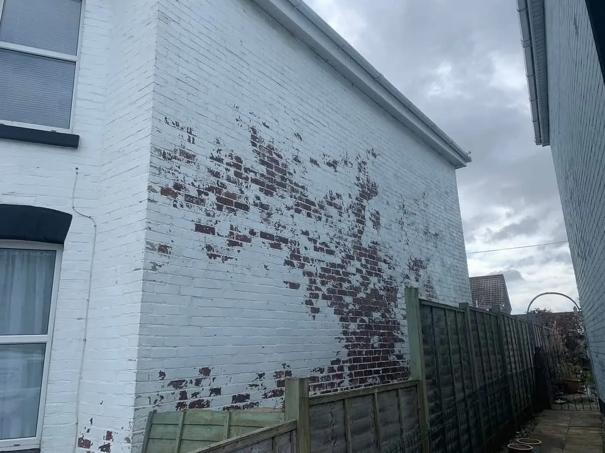Peeling paint on a brick wall before redecoration in Porthleven